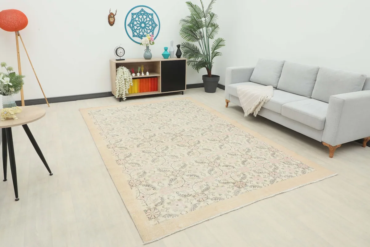 Large Ivory Floral Lattice Rug placed in a living room setting with a light gray sofa and modern decor.