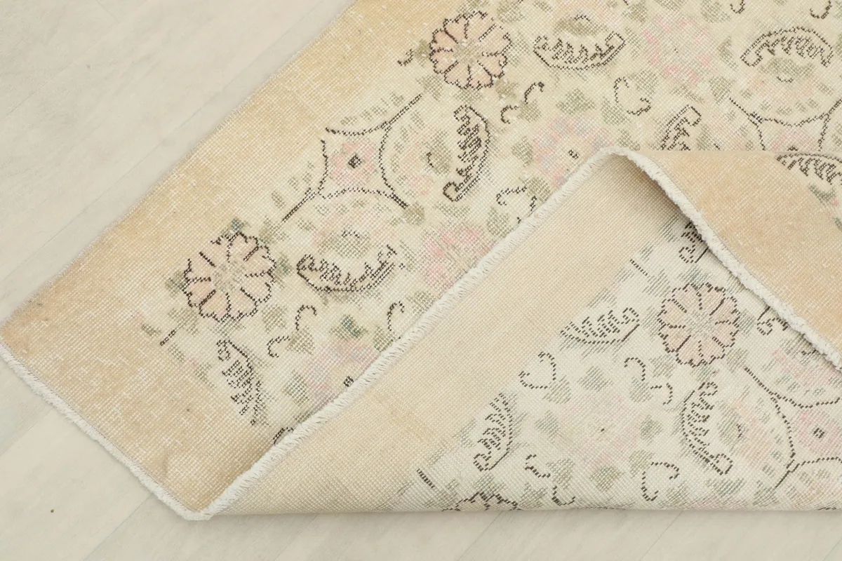 Corner of the rug folded back, displaying the consistent pattern on both sides and the fringe detail.