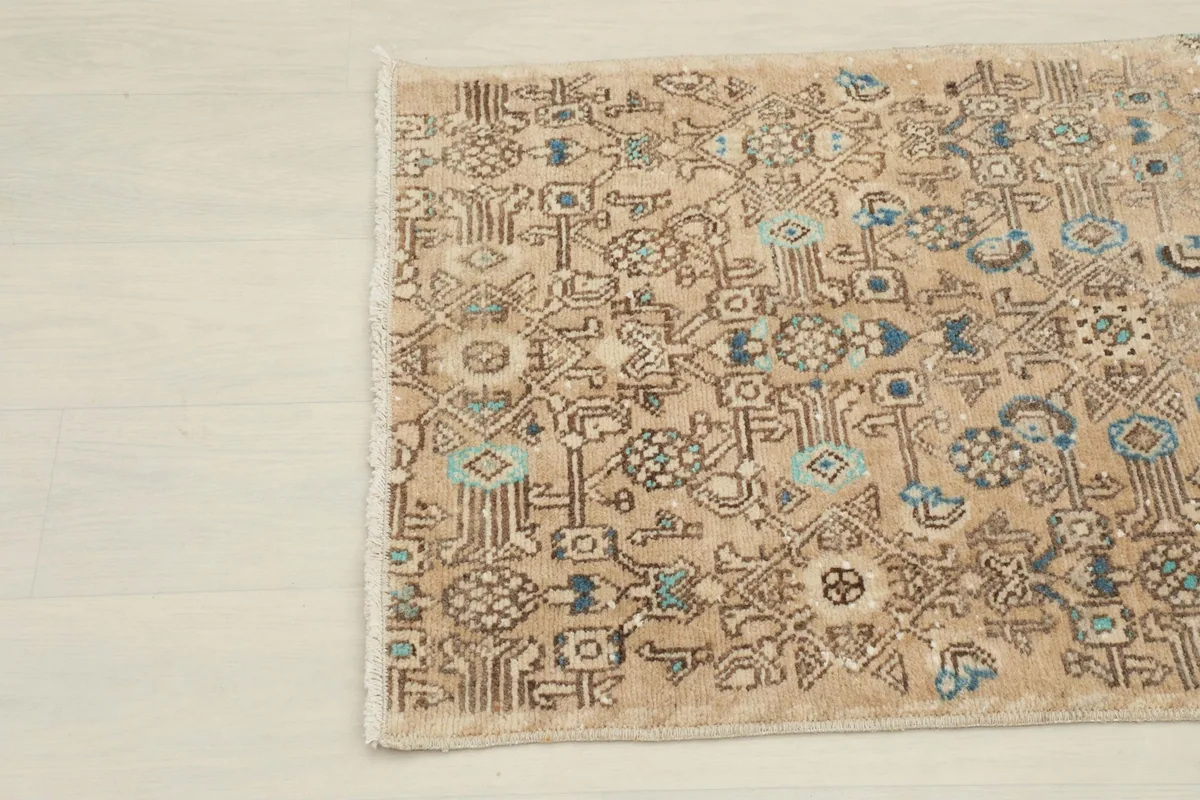Close-up of the upper left corner showing the intricate tan field and varied motifs.