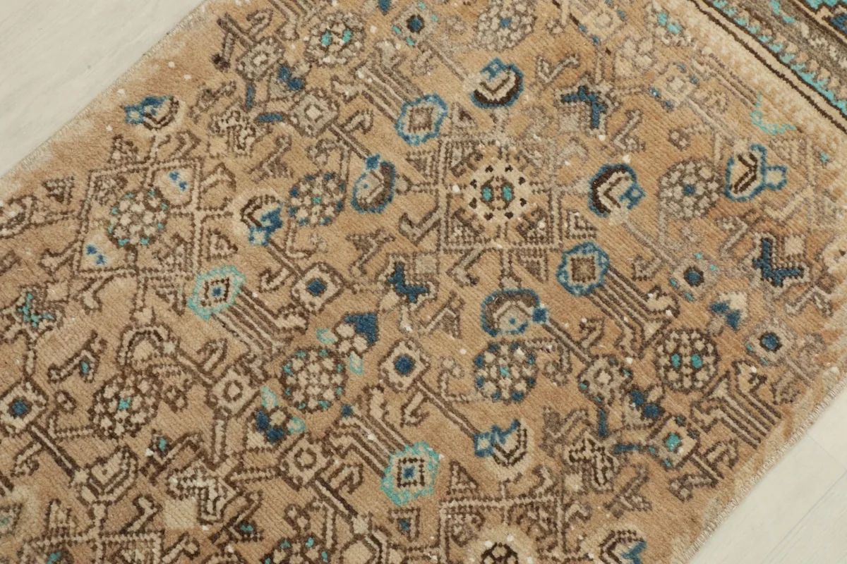Detail view of the rug's central field, showcasing the blue and green tribal designs.