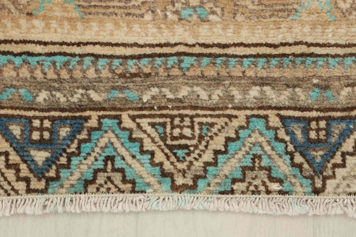 Close-up of the rug's lower border and fringe, showing the geometric details and texture.
