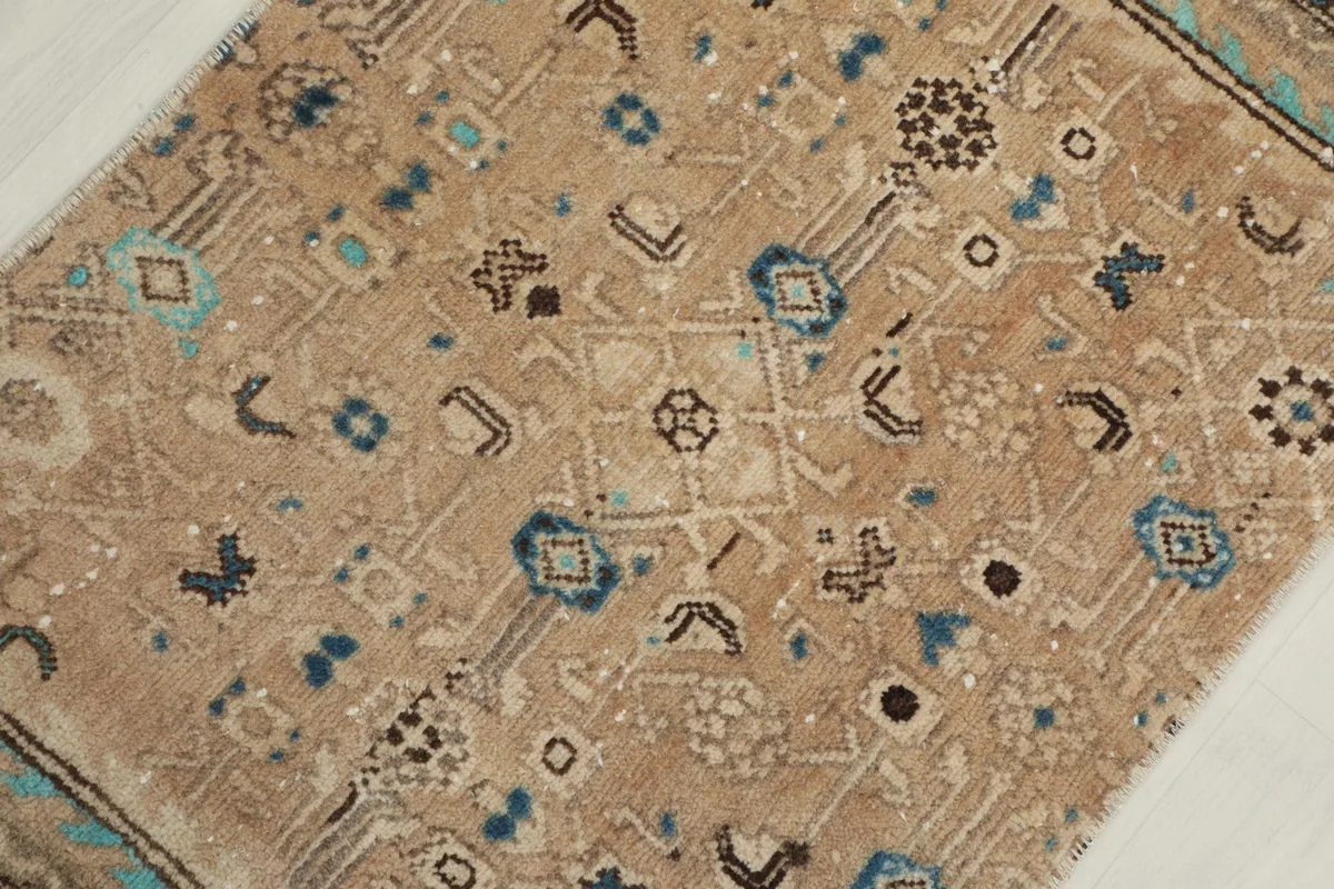 Detailed view of the tan field showcasing various blue and brown geometric motifs