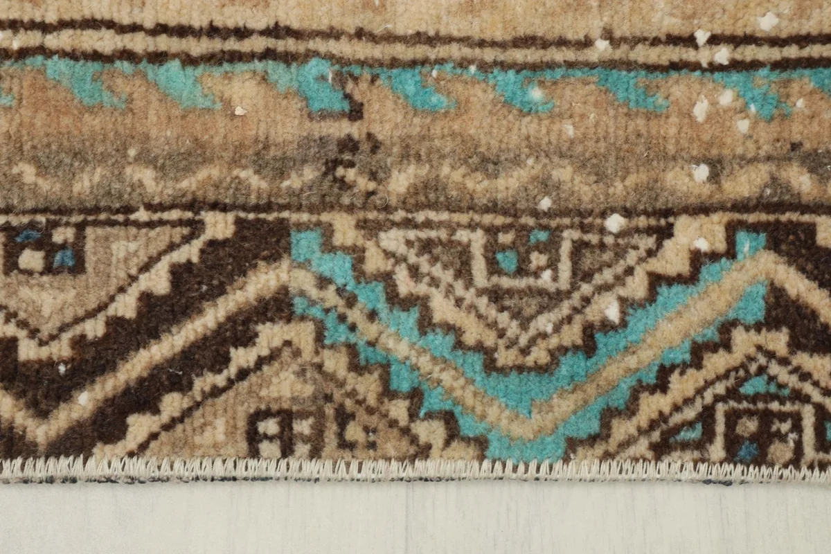 Close-up of the rug's edge and fringe, highlighting the pile texture and border patterns