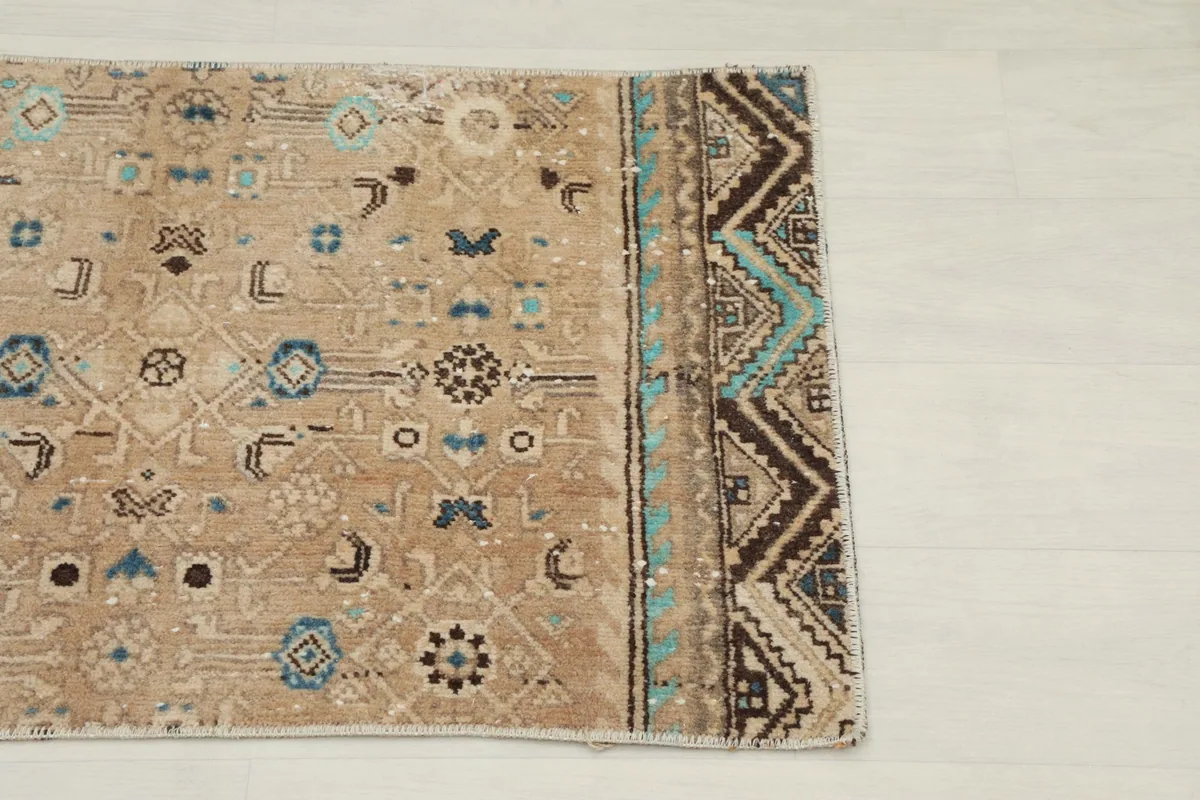 Close-up of the short end border featuring brown and blue geometric patterns