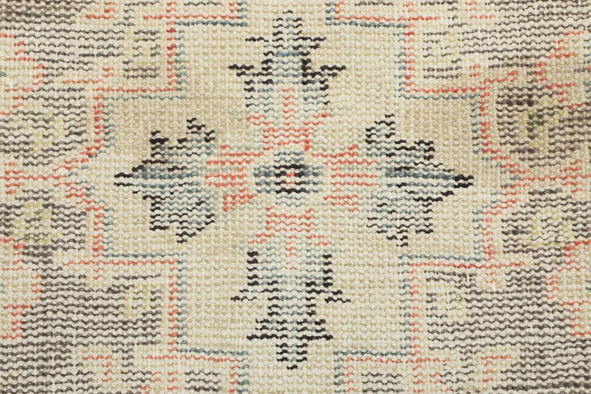 Close-up showing the hand-knotted wool pile and cotton foundation, revealing low pile texture