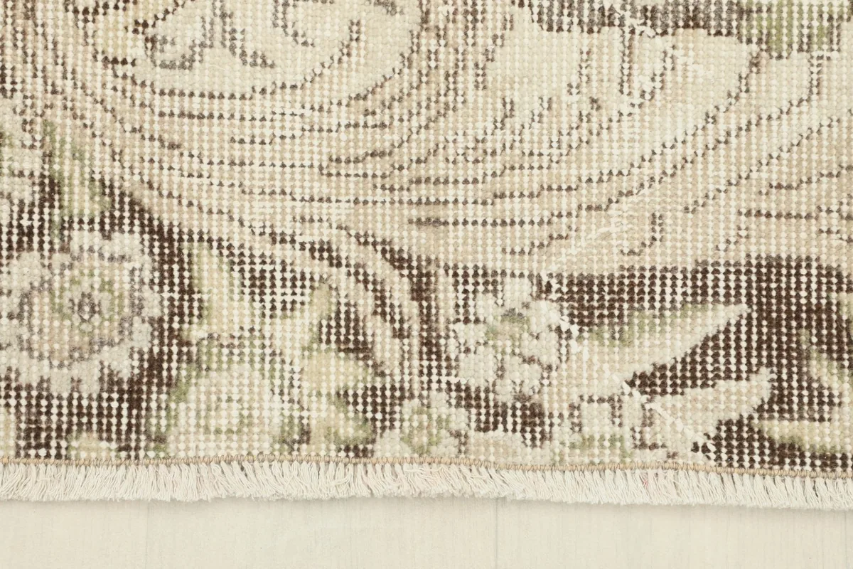 Detail of the rug's edge, showcasing the short, natural fringes and border pattern