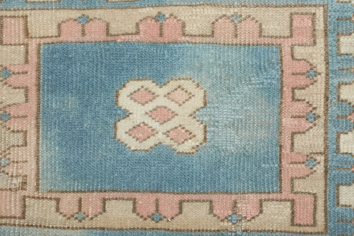 Close-up of the small inner blue rectangle within the medallion, showing intricate pink and ivory motifs