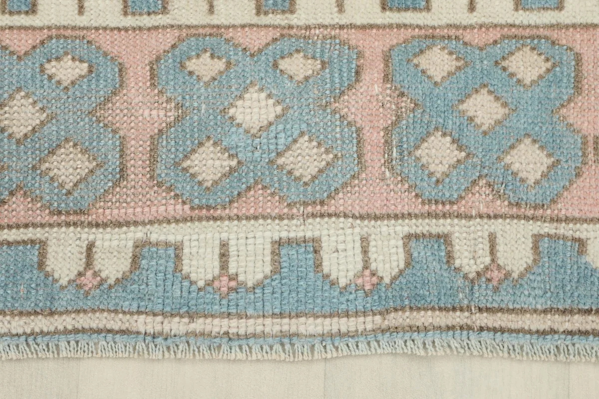 Detailed view of the main border with repeating blue geometric shapes and ivory accents