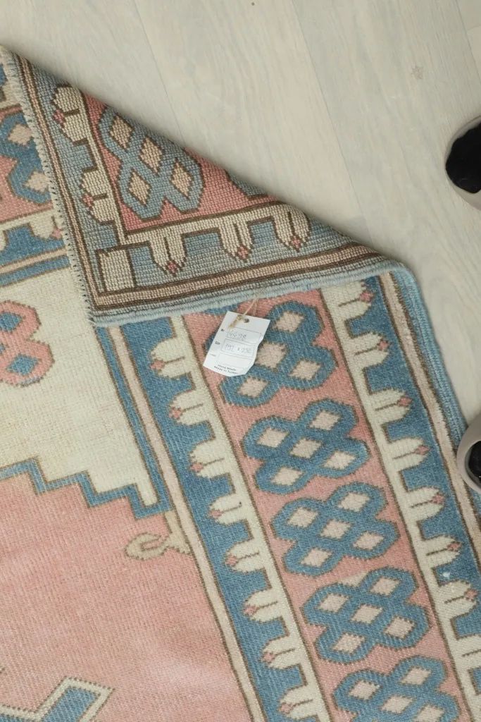 Underside view of the rug near the edge, showing the tightly woven cotton foundation and short fringe