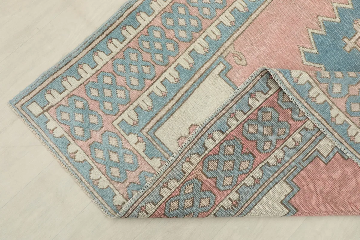 Folded corner of the rug, revealing the wool pile texture and cotton foundation