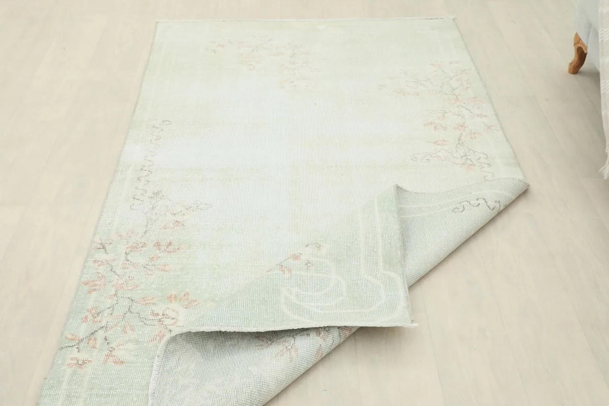 Rug partially folded back, revealing the reverse side and the clean cotton foundation