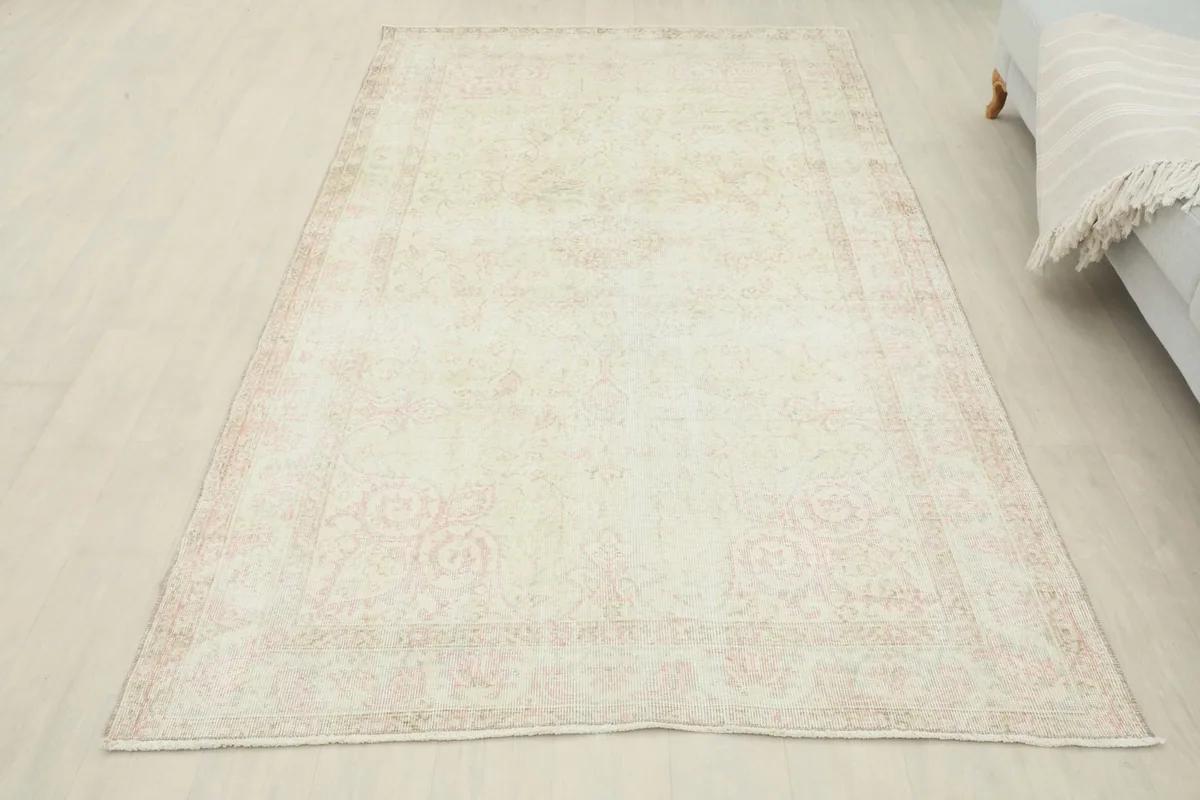 Vintage Anatolian rug with ivory and rose tones in a room setting, showing full size and color