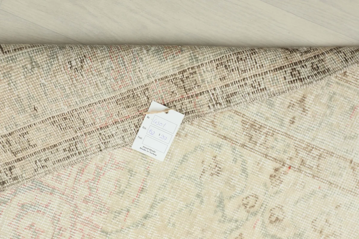 Close-up of the rug's back with a product tag, revealing the tight knotting and foundation