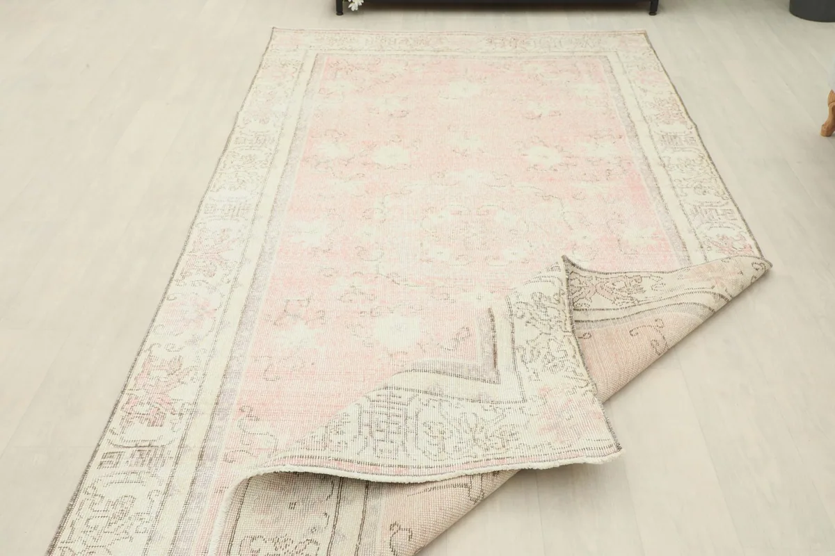 Rug partially folded, displaying the flexibility and thickness of the vintage wool on cotton