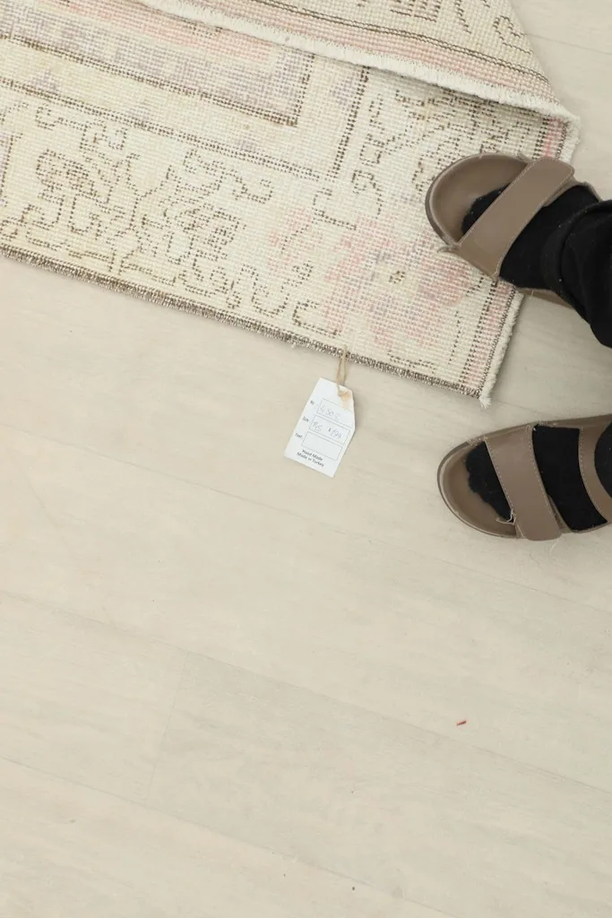 Overhead view of a foot on the rug, showing the scale and the soft texture of the wool pile
