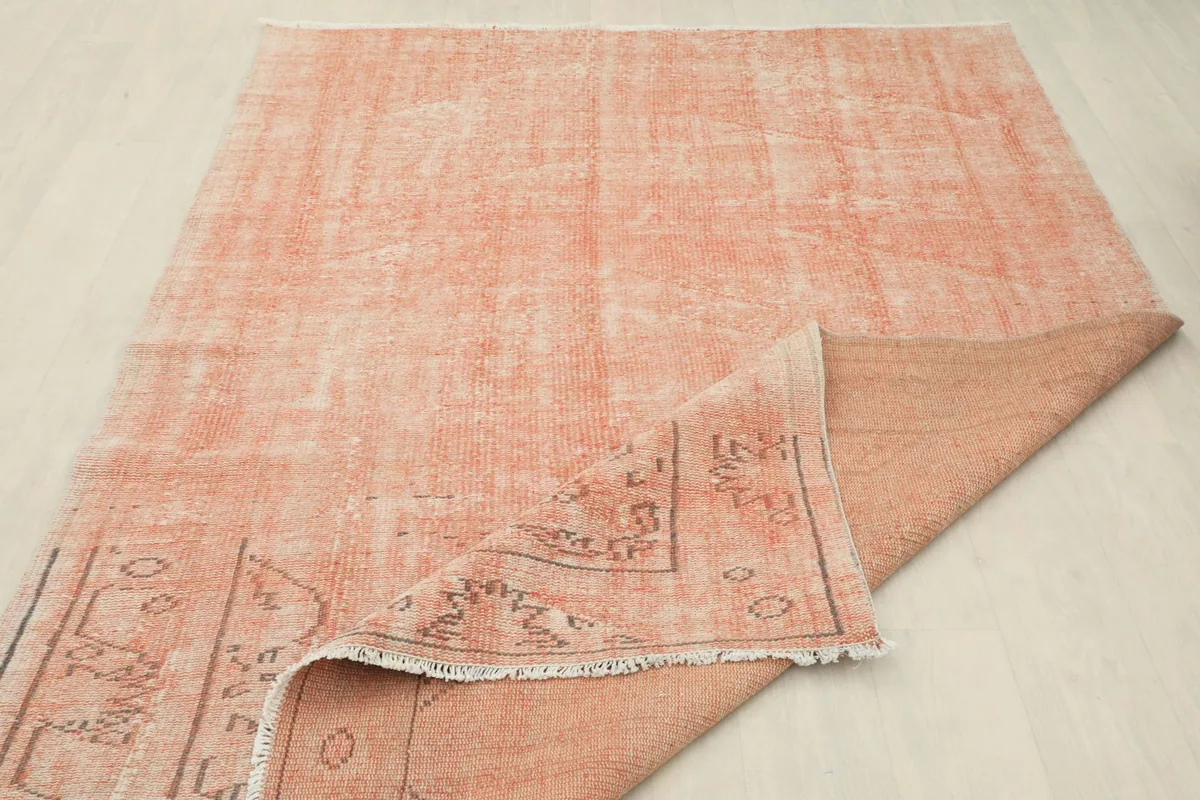 View of the rug's underside, showing the cotton foundation and the reverse of the hand-knotted wool pile.
