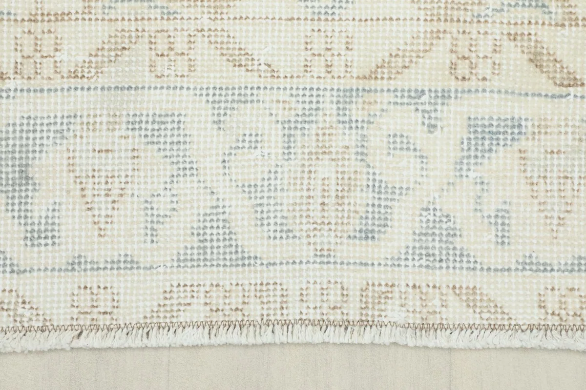 Close-up of the short, natural fringes and the end of the rug, showing the hand-knotted texture.