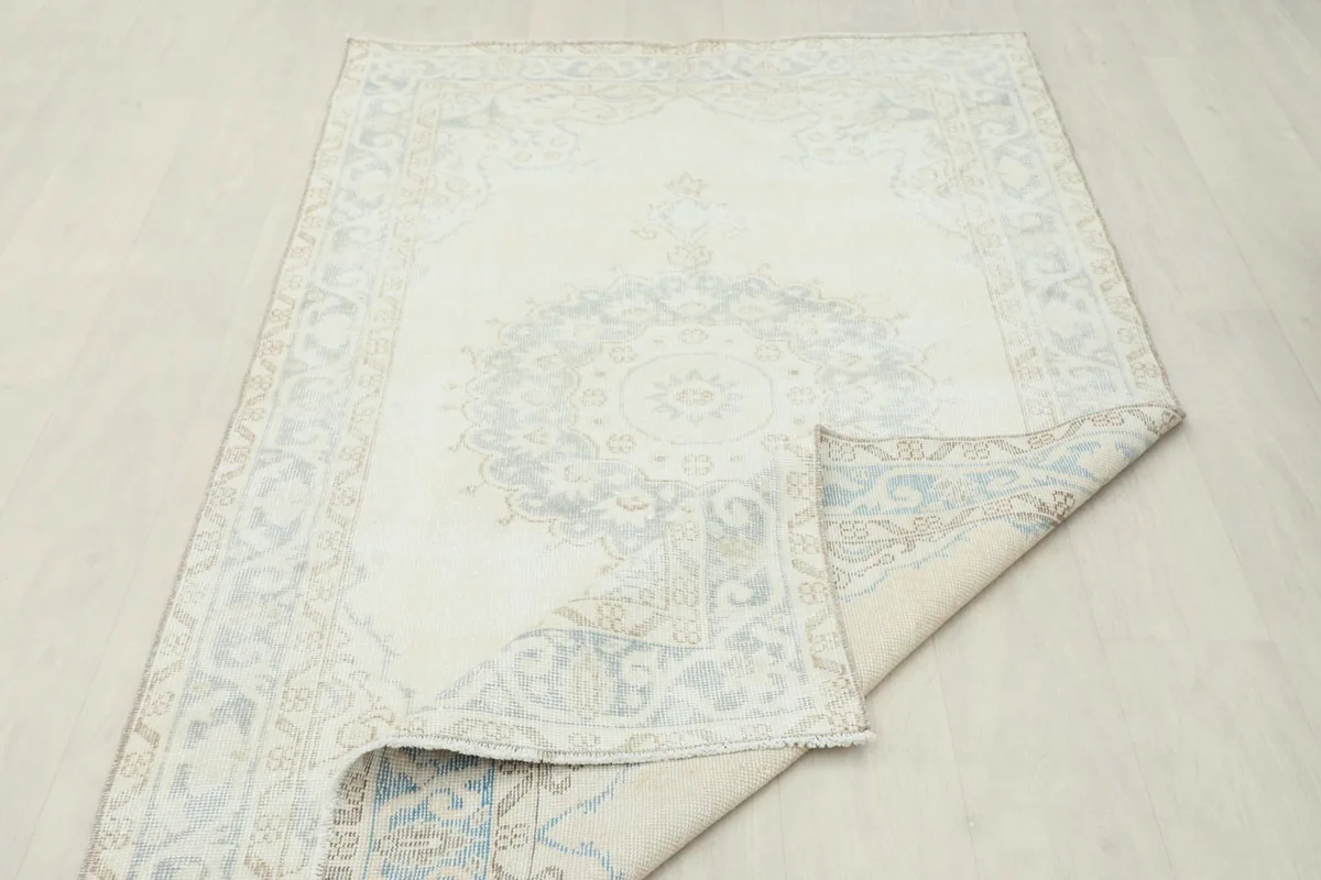 Rug partially folded, displaying the thickness and the back of the rug along with the pile.