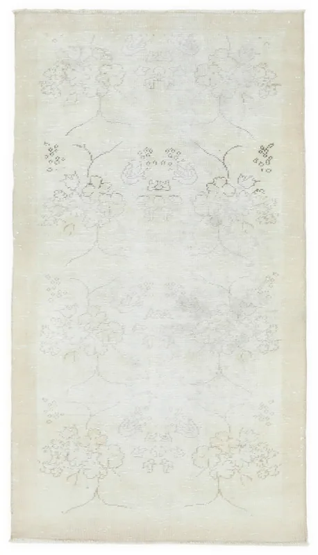 Full top view of the 3'7" x 6'4" vintage ivory Anatolian rug with faded floral patterns.