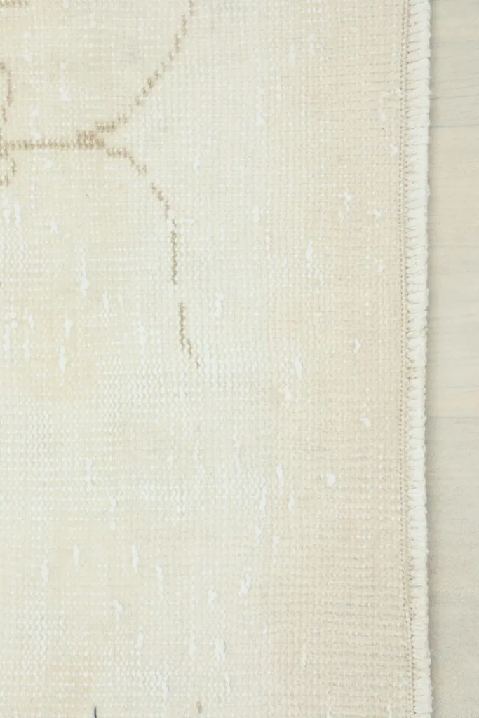 Detail of the rug's edge, illustrating the clean finish and the hand-knotted wool on cotton foundation.