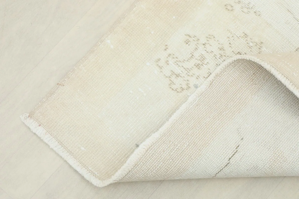 Underside of the rug, folded to show the cotton foundation and the reverse of the hand-knotted construction.
