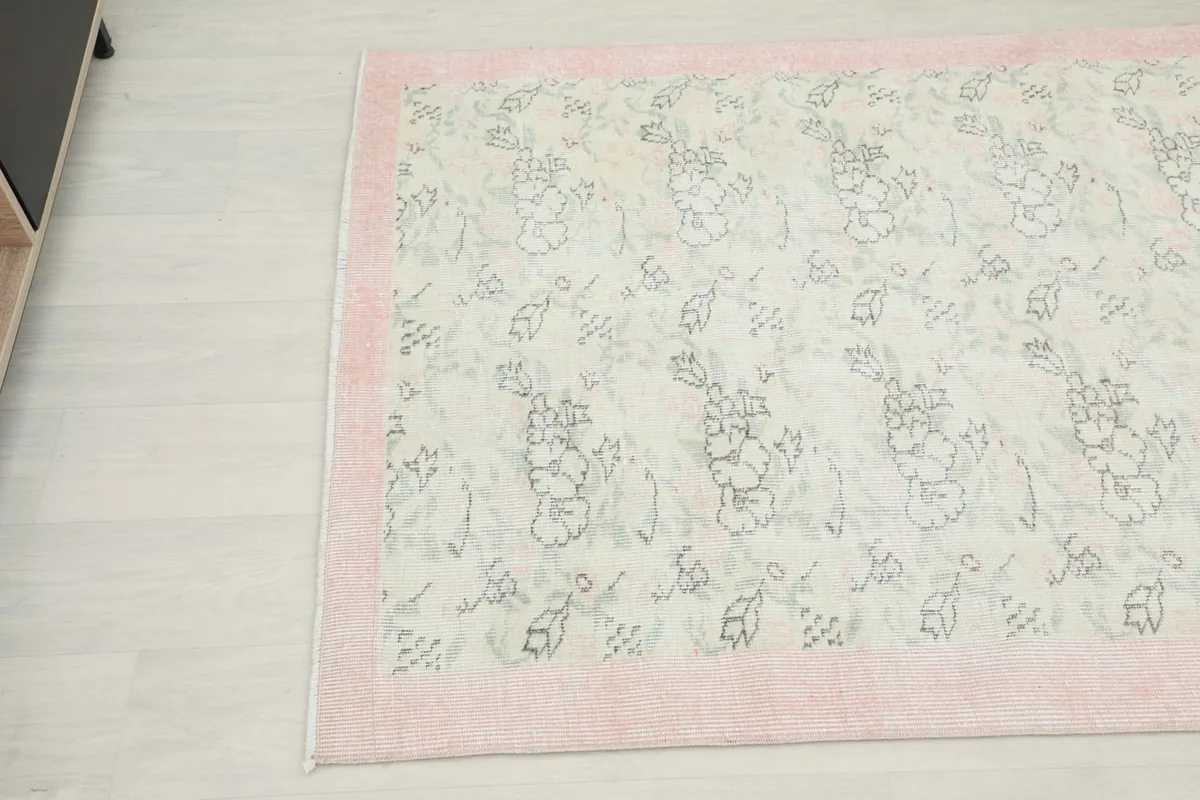 Close-up angled shot of the rug's surface, showing the subtle color variations and hand-knotted texture.