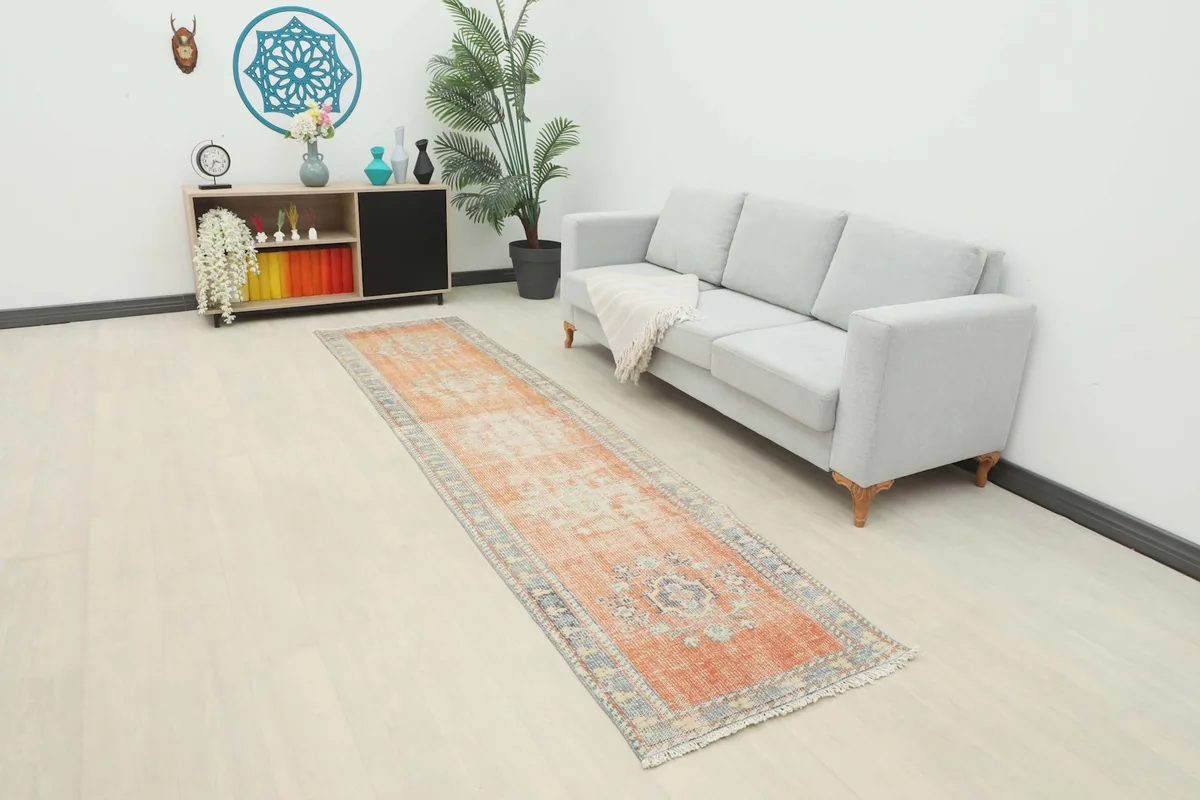 Full room view showcasing the vintage rust runner rug extending down a hallway next to a light gray sofa.