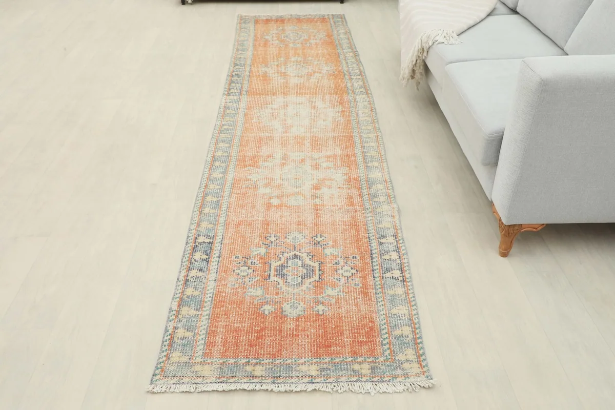 Full overhead view of the rust runner rug in a room setting, showcasing its complete design and colors.