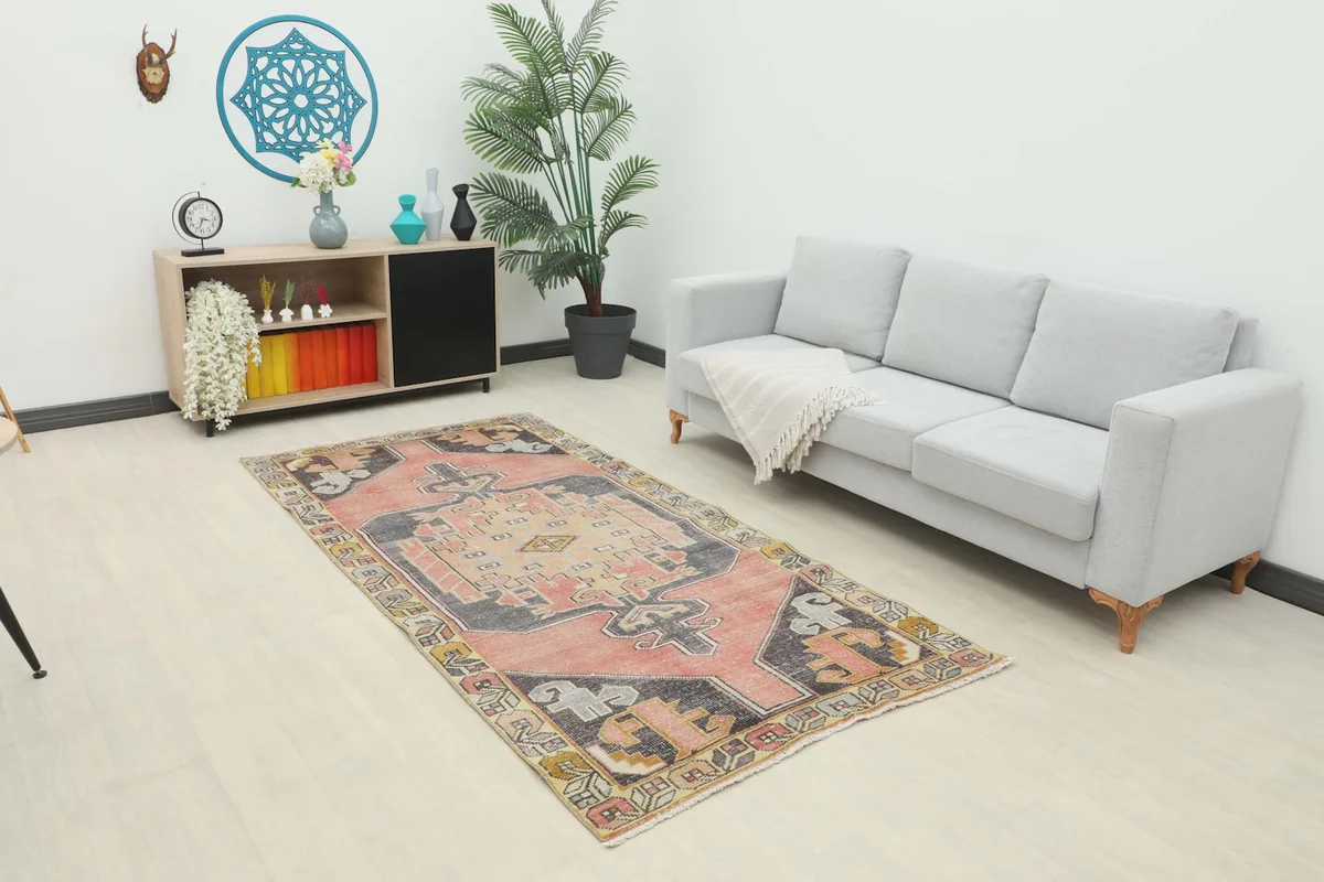 Vintage Anatolian rug displayed in a living room setting with a light gray sofa