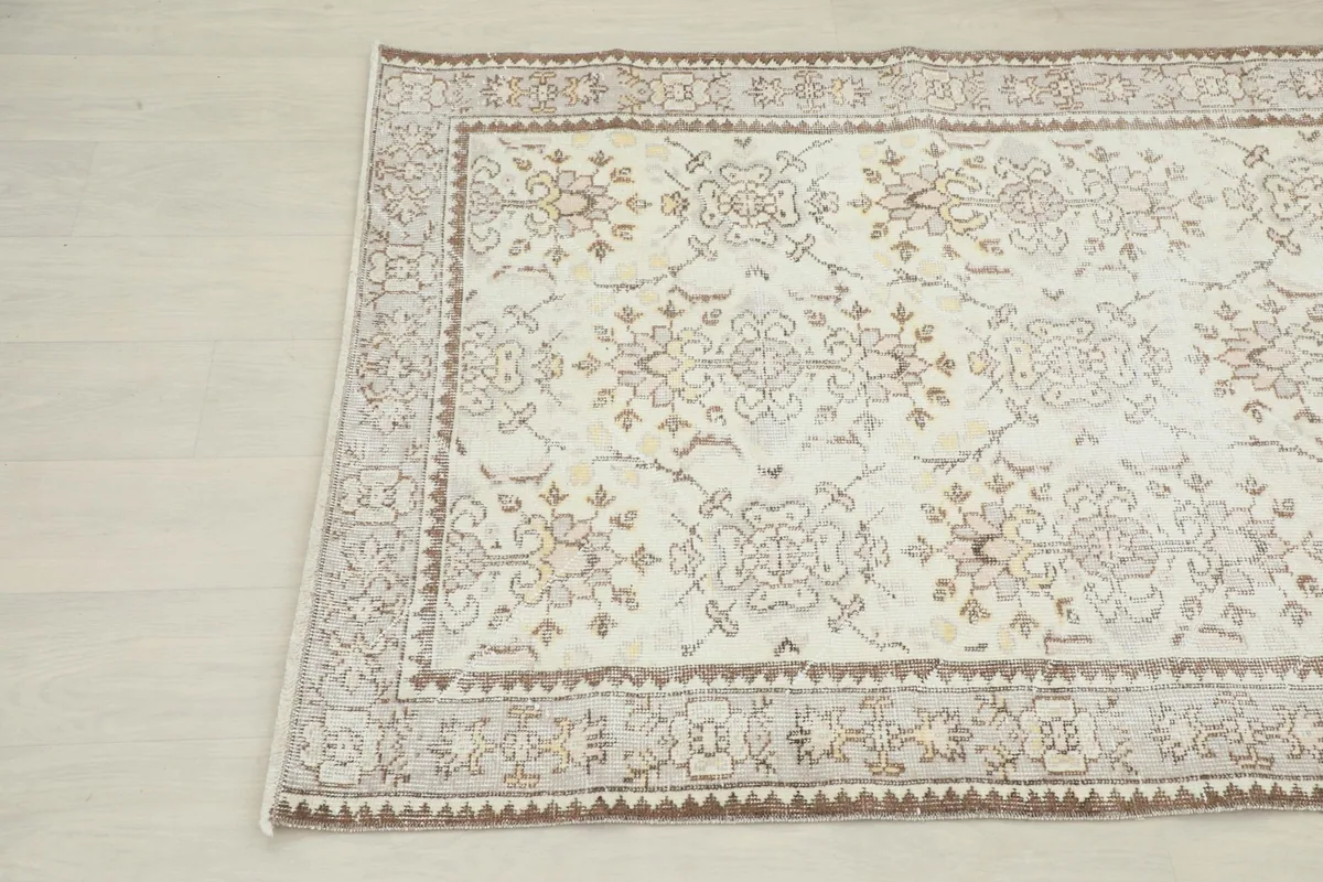 Another angle shot highlighting the distressed texture and beige motifs on the ivory field