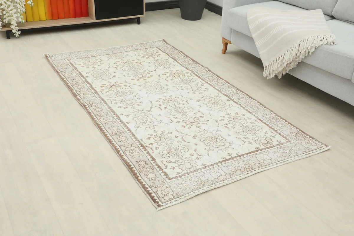 Ivory and beige vintage rug in a modern living room setting with a light gray sofa