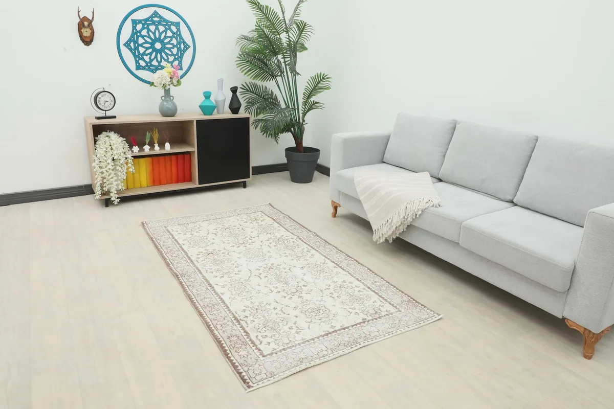 Overhead view of the ivory and beige rug placed in a room with a sofa and shelving
