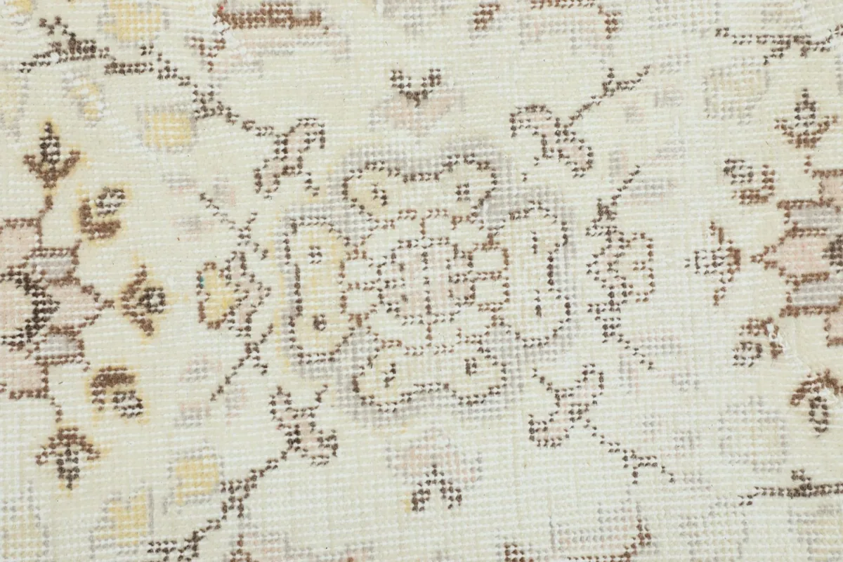 Extreme close-up of a single floral motif showing the hand-knotted wool pile