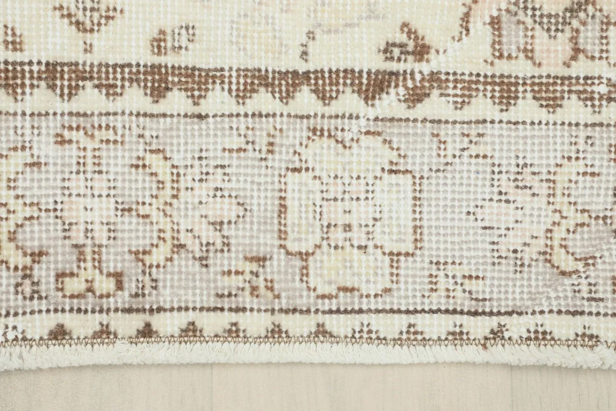 Close-up of the rug's border, showcasing the intricate beige and gray geometric design