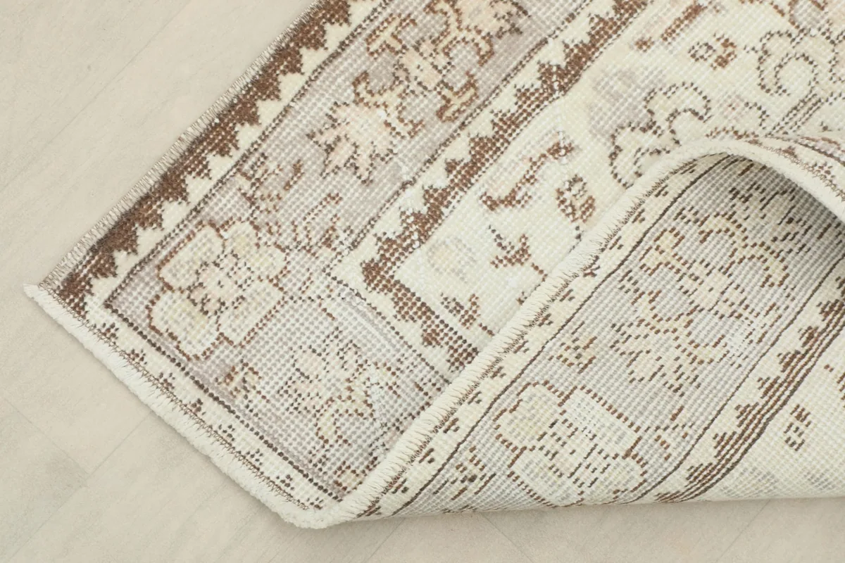 Corner of the rug folded back, revealing the backside and construction