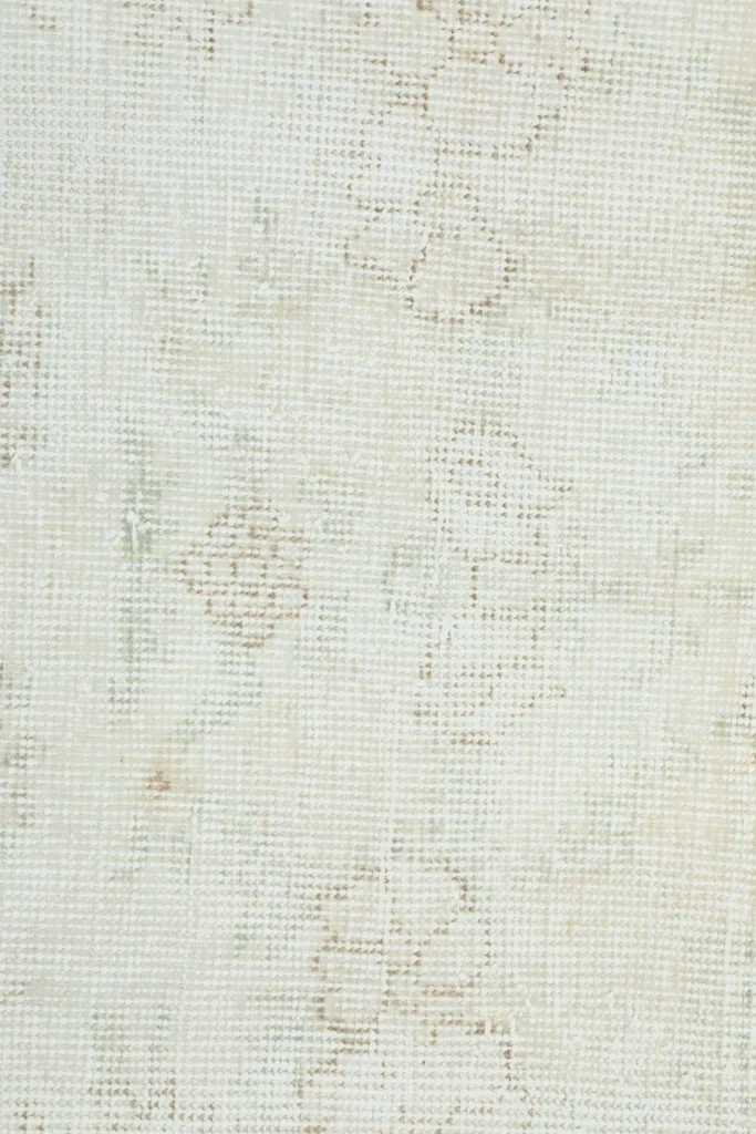 Extreme close-up of the low wool pile, showing individual knots and the faded design