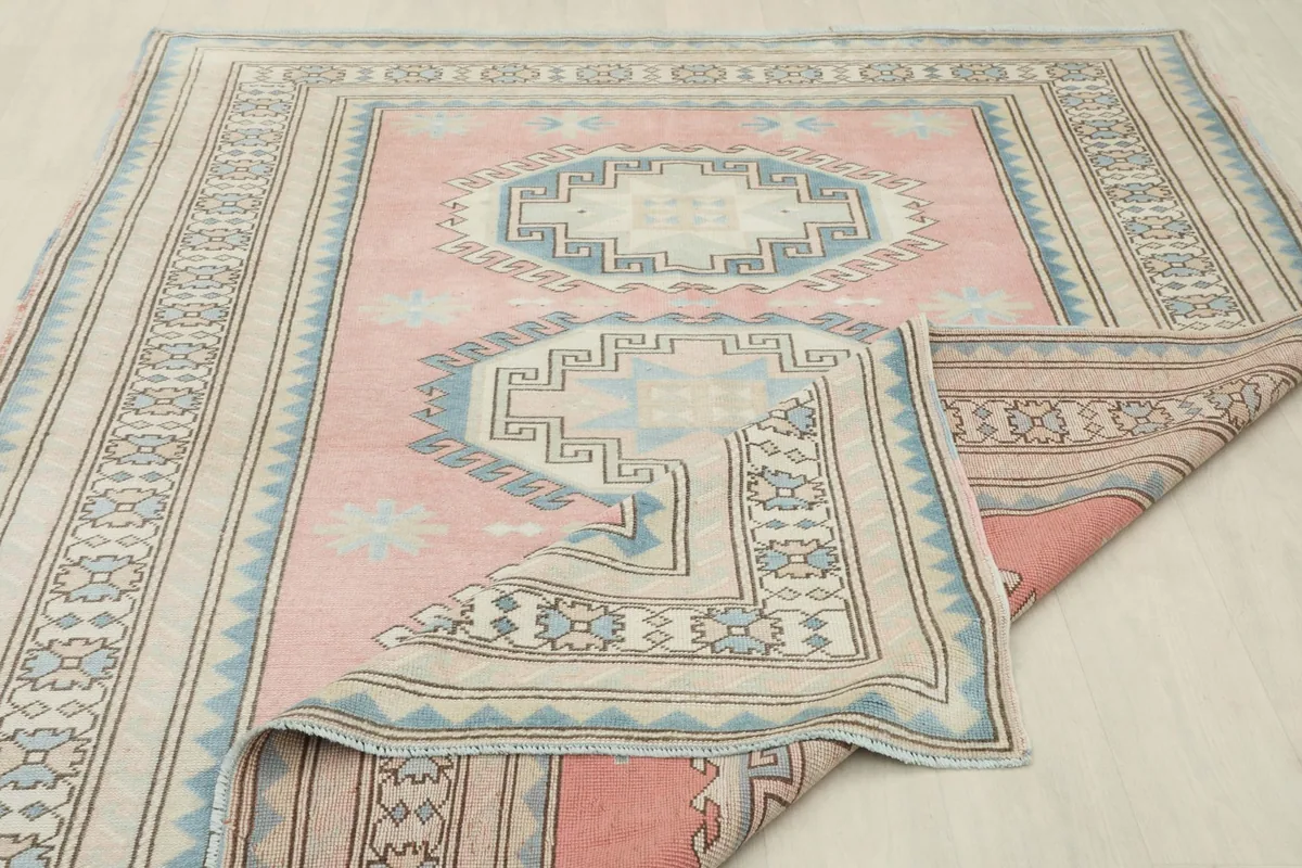Partial view of the rug's back, showing the hand-knotted cotton foundation and wool pile