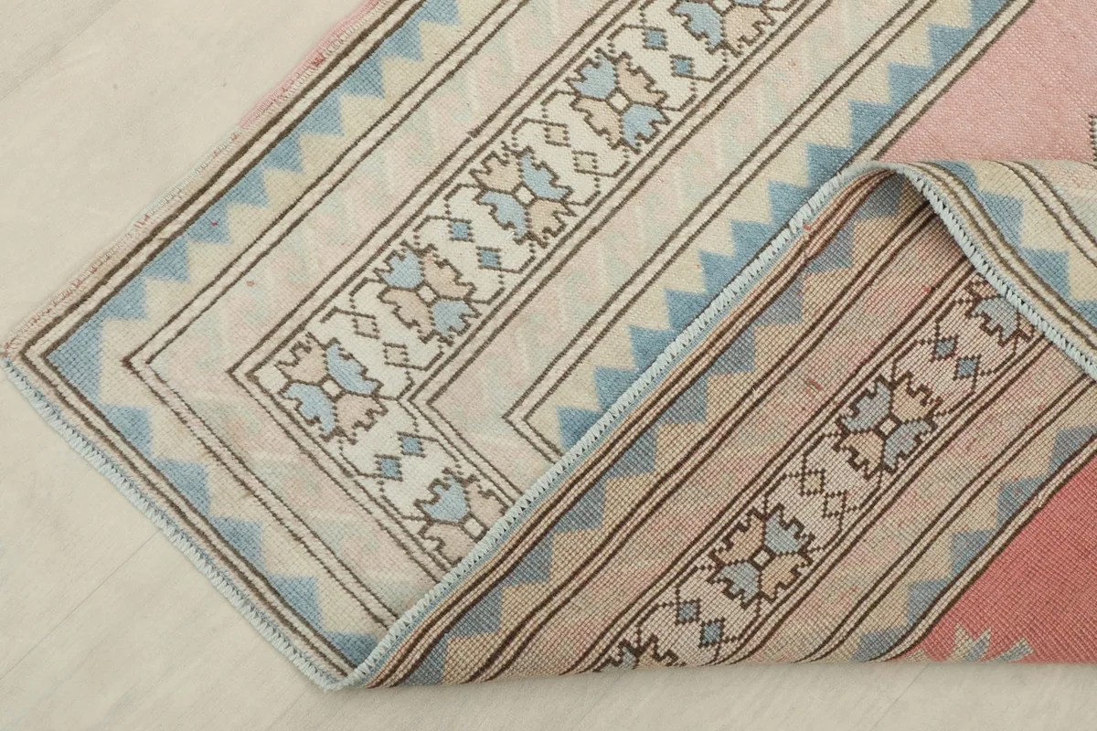 Folded corner of the rug, revealing the reverse side of the border and fringe