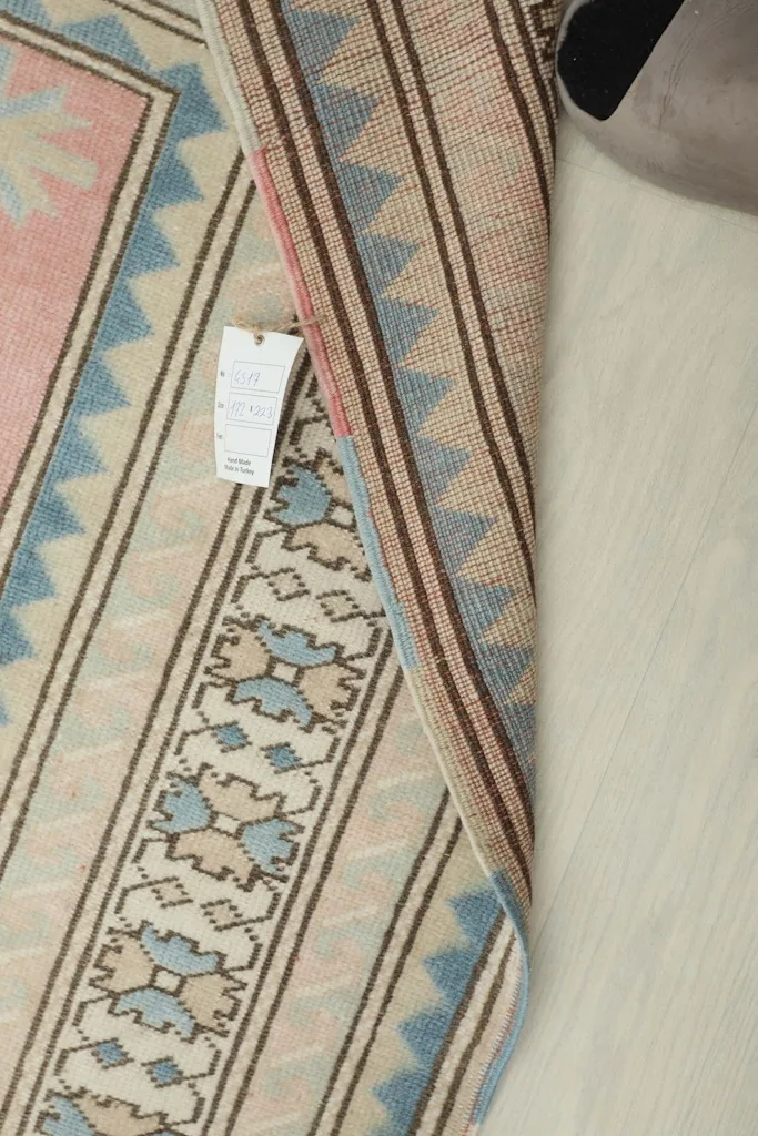 Close-up of the care tag attached to the rug's back, near the fringe