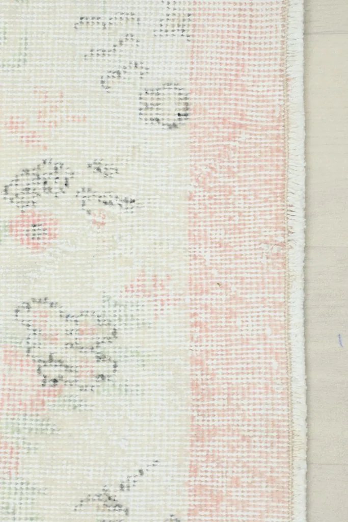Close-up view of the rose border and a section of the ivory field with its floral motifs
