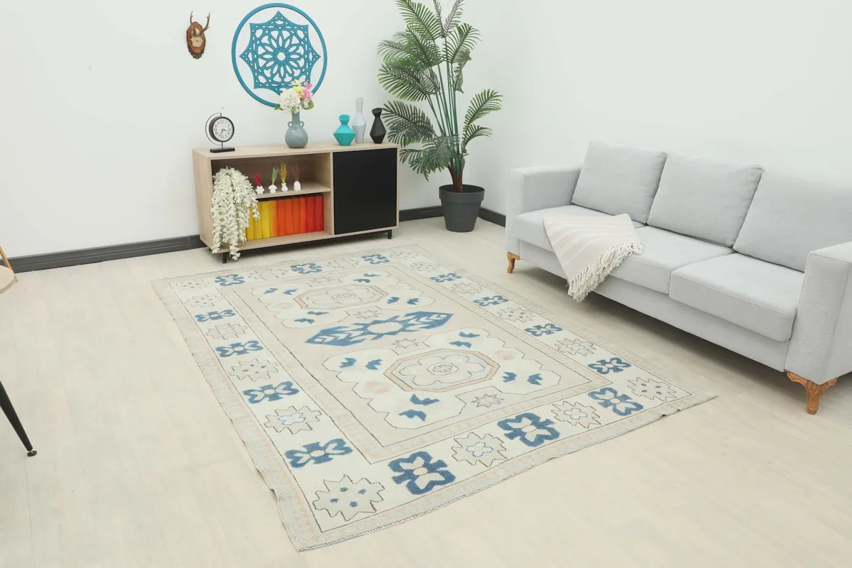 Vintage Anatolian rug displayed in a bright room setting with a light gray sofa