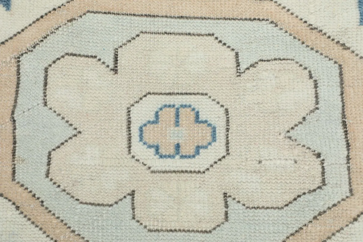 Macro detail of a stylized floral-geometric motif in beige with a blue center