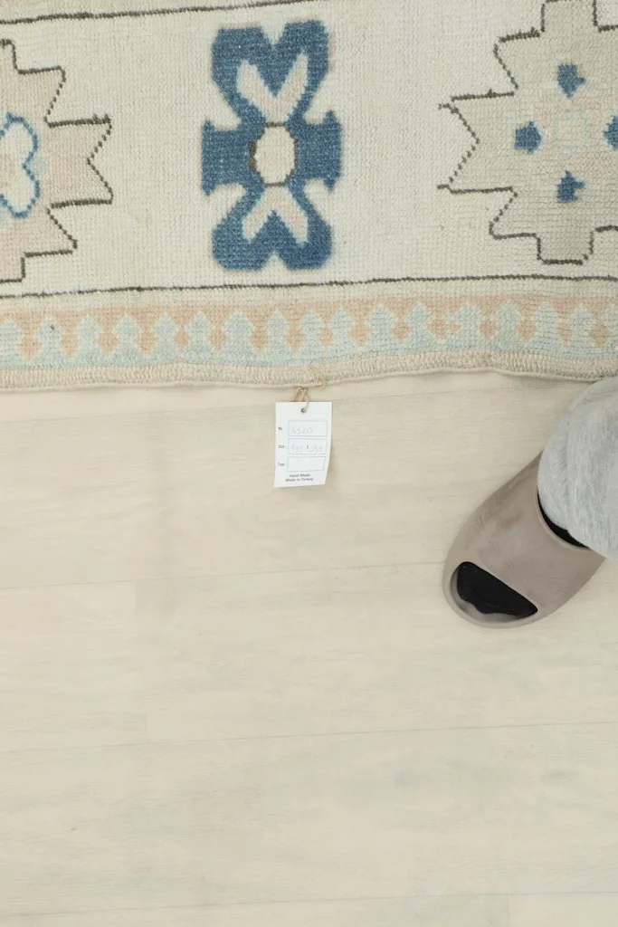 View of the rug's backside with a tag, demonstrating the tight knotting and wool material
