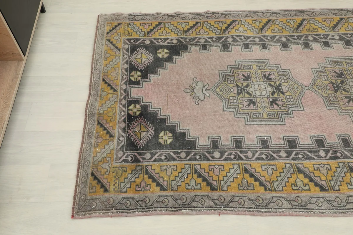 Another angle view highlighting the gray and gold geometric border of the rug