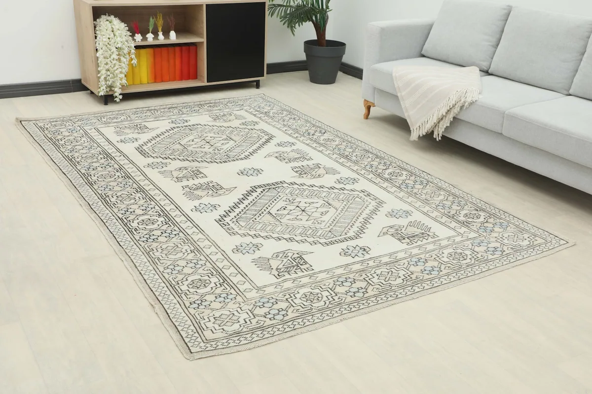 Angle view of the ivory and gray geometric rug in a living space, showing its full length.