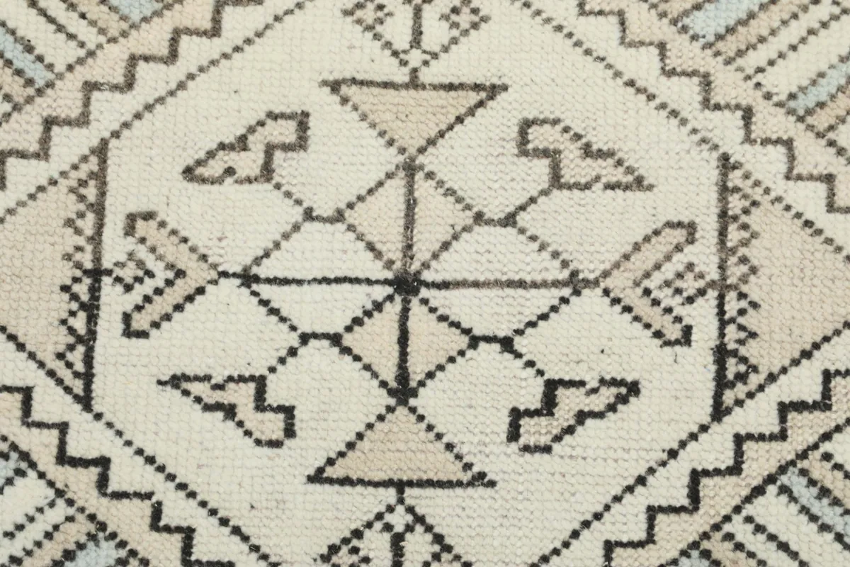 Extreme close-up of a central geometric medallion with intricate lines and beige accents.
