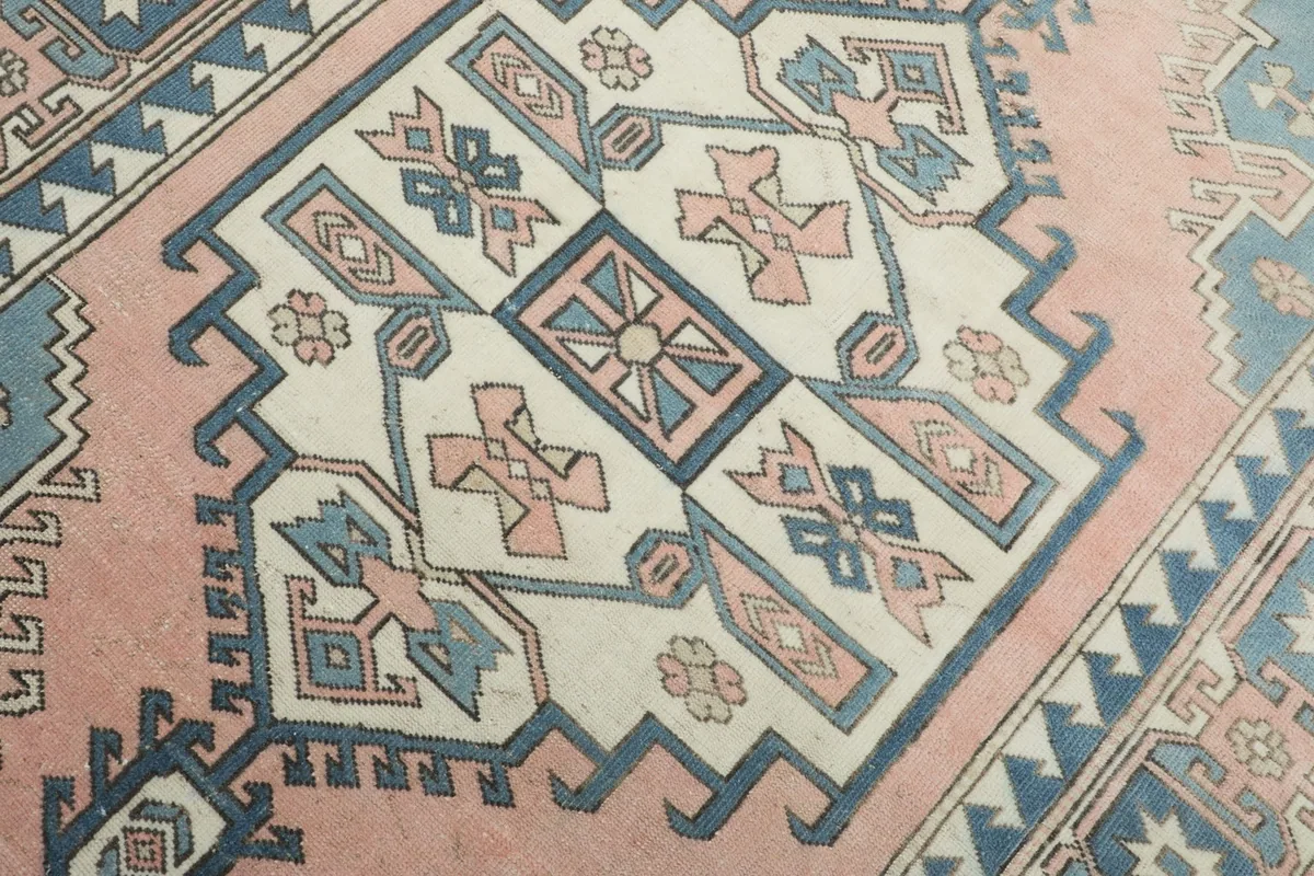 Close-up detail of the central ivory medallion and surrounding rose and blue tribal motifs