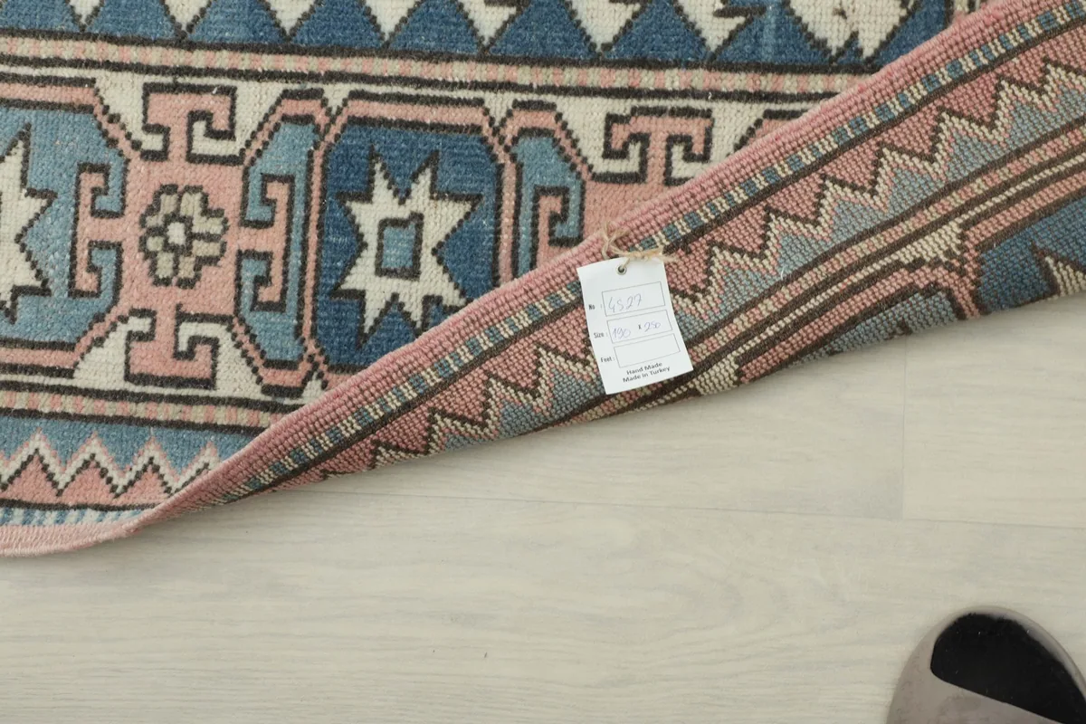 Detailed view of the rug's reverse side and edge, revealing the hand-knotted construction