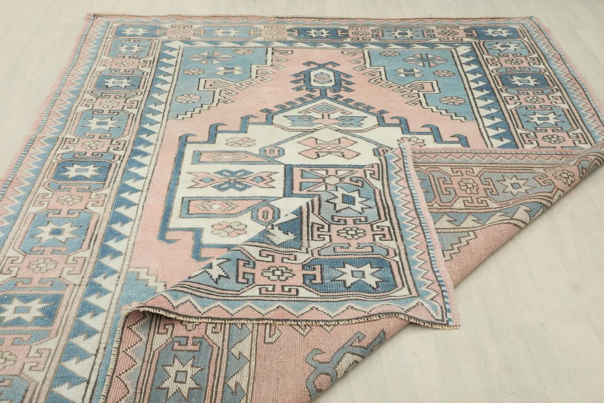 Another folded view of the rug, displaying the reverse side and the hand-knotted cotton foundation