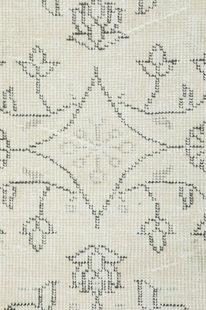 Detailed close-up of the hand-knotted wool pile, revealing the texture and faded gray patterns.